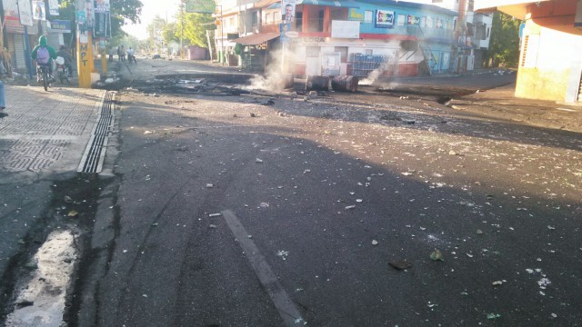-Botellas rotas, escombros y neumáticos humeantes en la carretera Duarte en Licey al Medio, foto Rafael Pérez