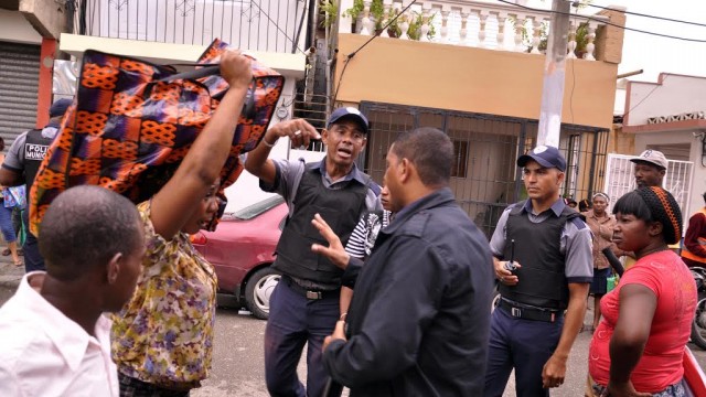 Policías municipales evitan esta mañana que vendedores haitianos instalen sus puestos en las calles de Pueblo Nuevo. Foto Alex Reynoso.